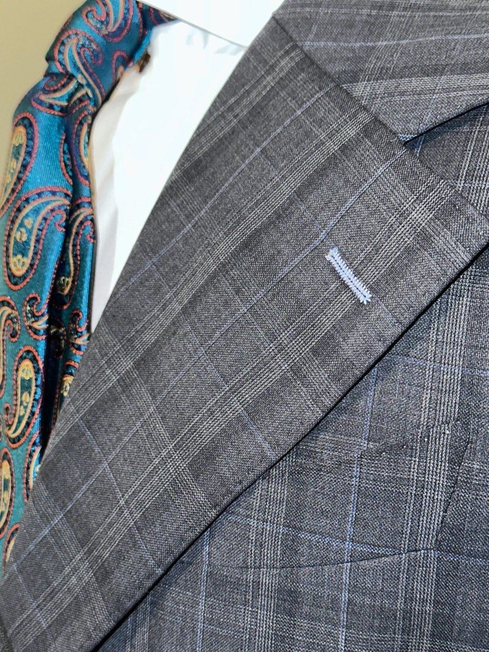 Gray plaid suit lapel with teal paisley tie