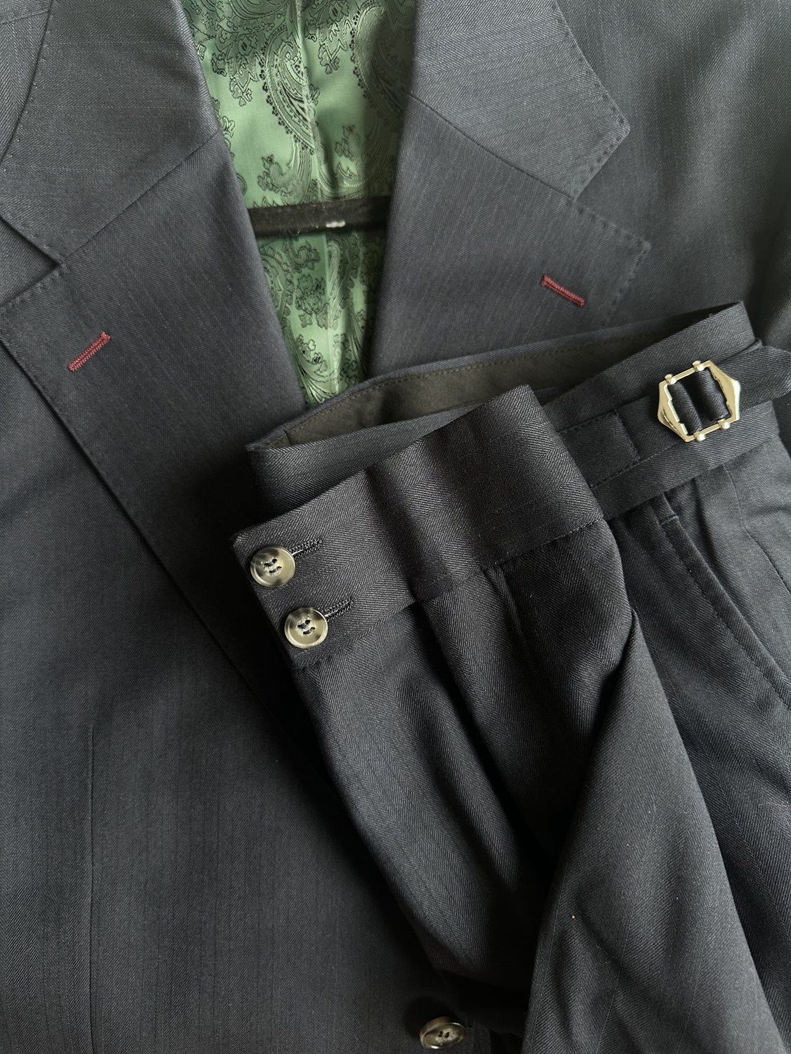 Black suit details with green lining and red buttonholes