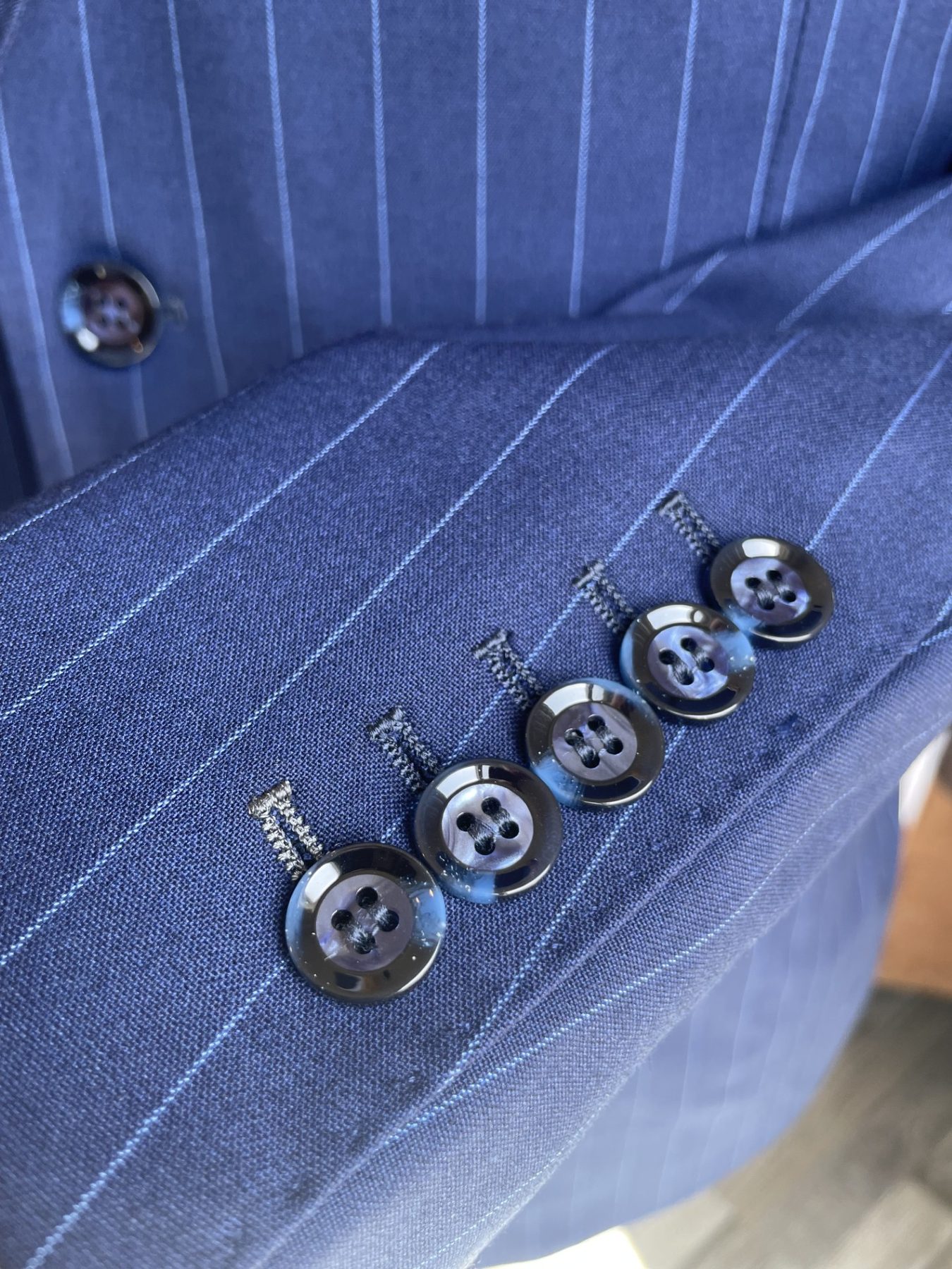 Blue pinstripe suit sleeve buttons and fabric detail